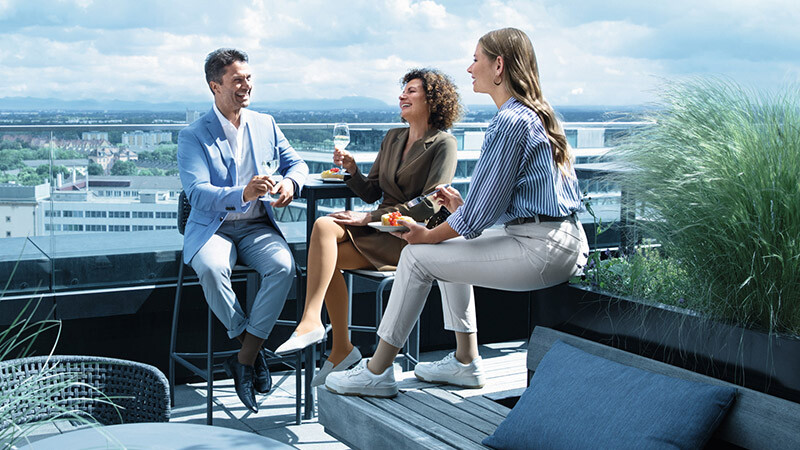 A man and two women wearing compression stockings are on a roof terrace A man and two women wearing compression stockings are on a roof terrace