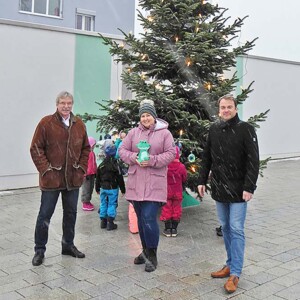 Weihnachtsbaum schmücken Uwe Schettler und Jürgen Gold (von links) freuen sich mit der stellvertretenden Kindergartenleitung des Julius-Kindergartens Jennifer Schade (Mitte) über den von den Kindergartenkindern geschmückten Weihnachtsbaum.