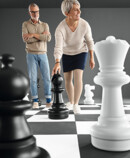 Man in Juzo Dynamic stockings kneeling on a large chessboard