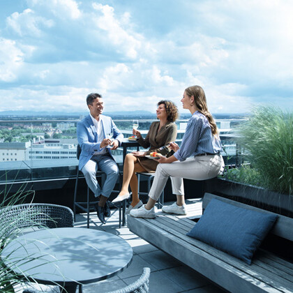 En mand og to kvinder befinder sig på en tagterrasse og har kompressionsstrømper på