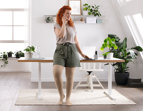 Een vrouw staat in haar woonkamer te bellen Een vrouw staat in haar woonkamer te bellen