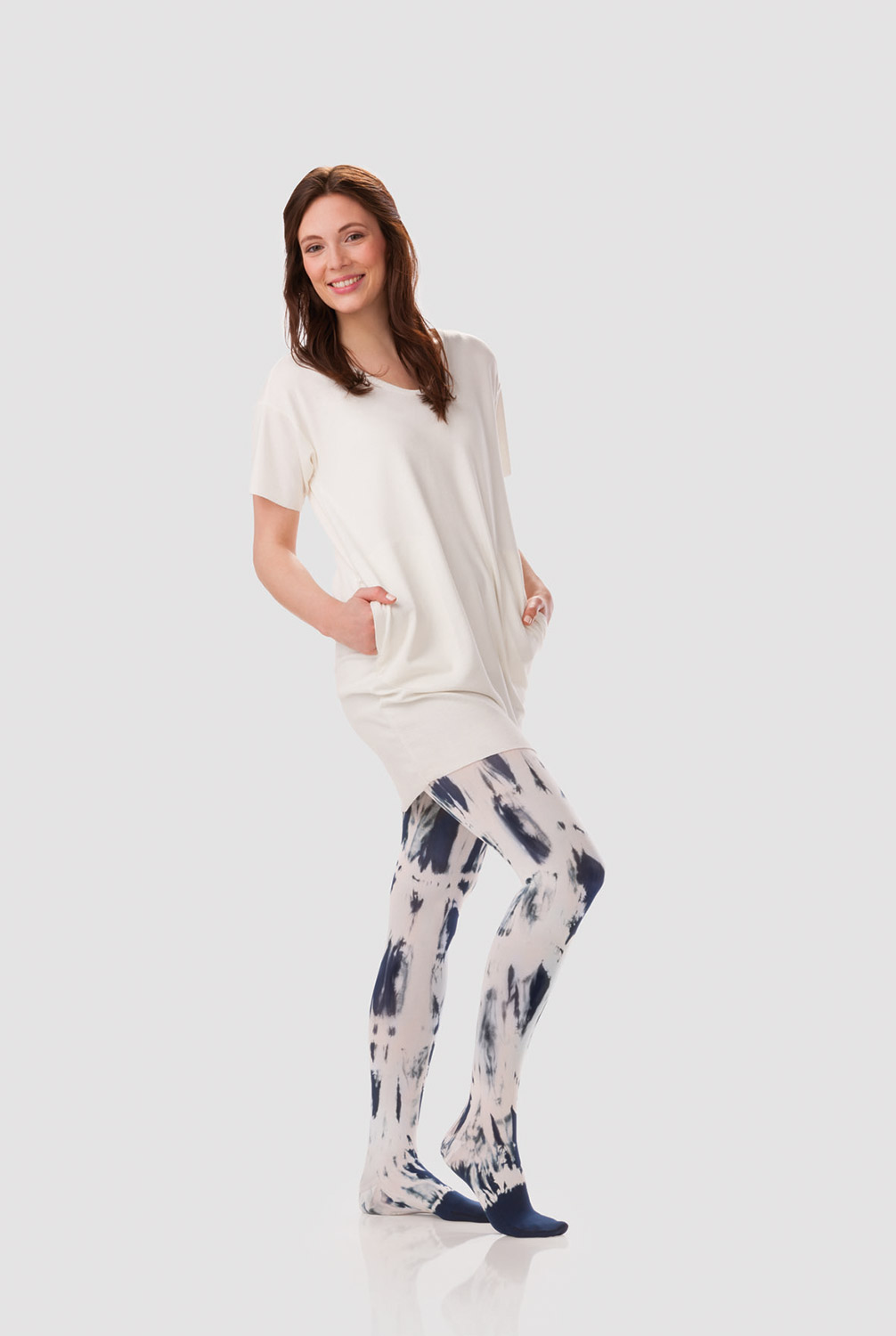 A woman is wearing a white dress with a compression garment in a white and blueberry tie-dye pattern A woman is wearing a white dress with a compression garment in a white and blueberry tie-dye pattern