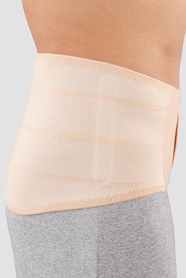 3rd product image Beige, side Man wearing the JuzoPro Lumbal back orthosis in straight shape