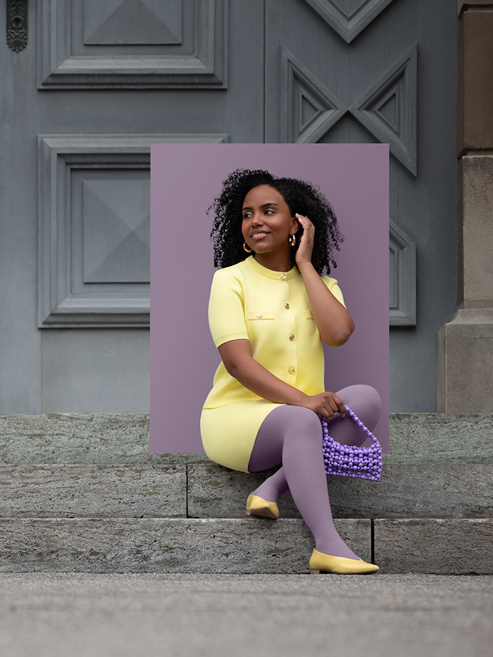 Cosy Violet A woman in a yellow two-piece outfit sits on steps wearing a Cosy Violet compression garment